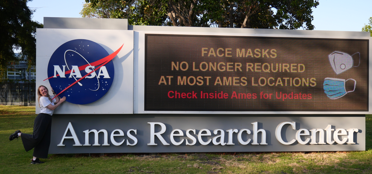 Katrina stands next to the Ames Research Center sign at Moffat Field